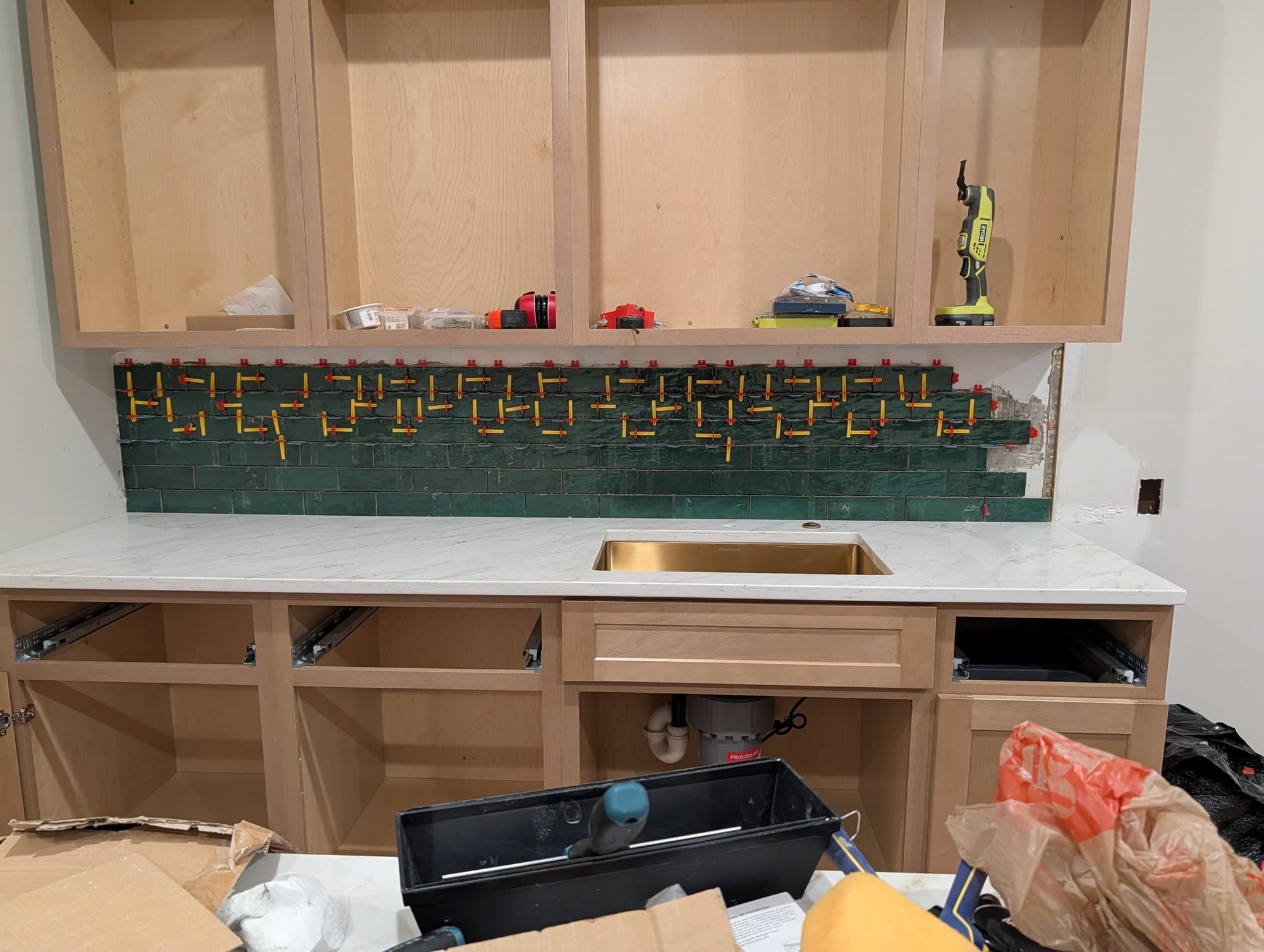 Basement wet bar during tile backsplash installation, with spacers still in place